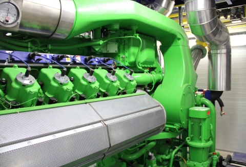 Der Motorblock eines Heizkraftwerks mit Ableitungsrohren im Hintergrund.